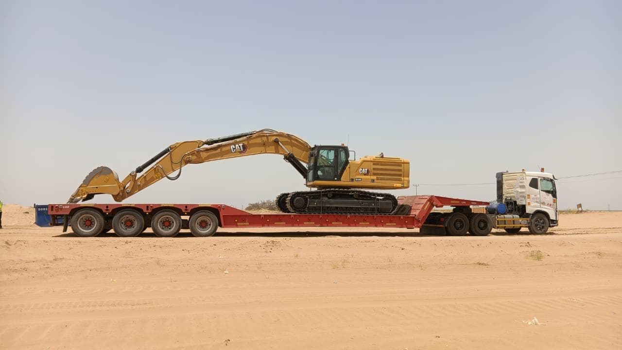 4-axle hydraulic lowbed carrying a CAT excavator