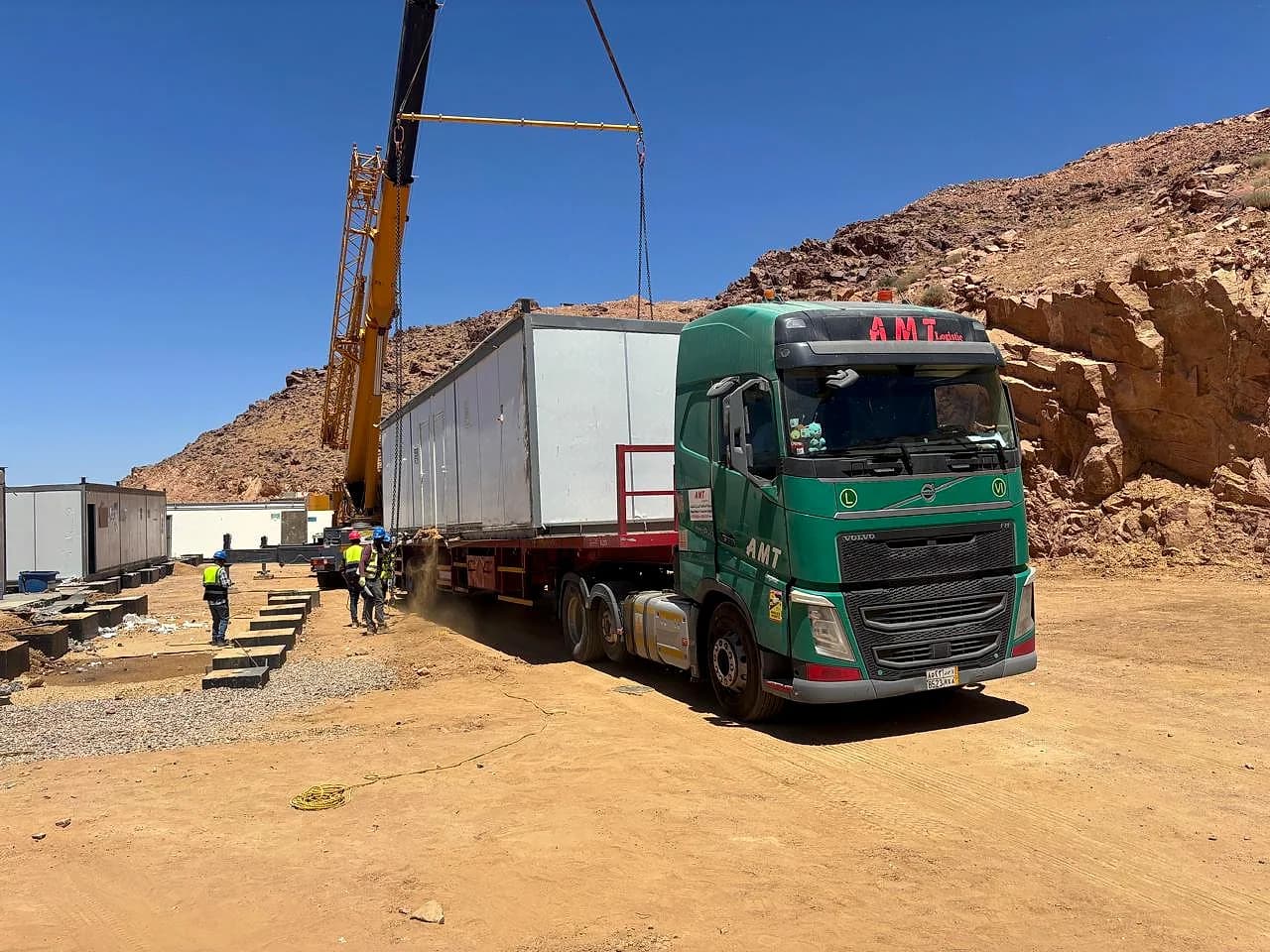 كرين يرفع كبينة جاهزة من لوبد AMT في موقع صخري