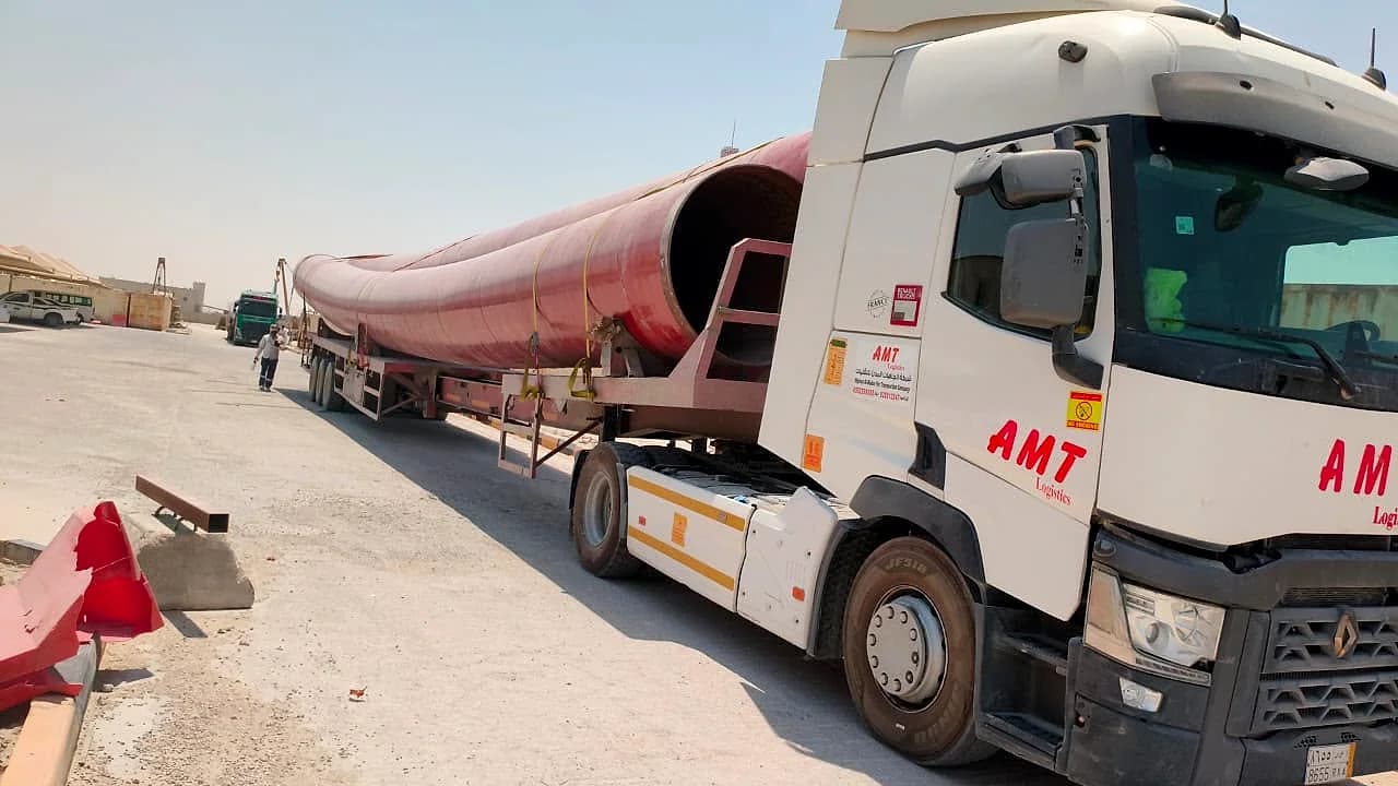 شاحنة AMT بجانب ماسورة فولاذية حمراء طويلة على لوبد